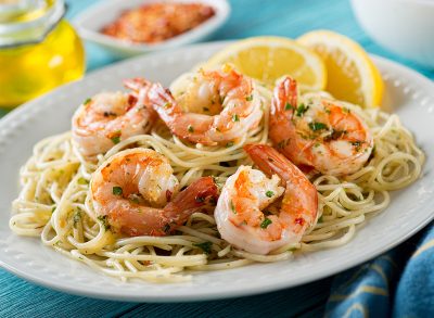 A delicious plate of shrimp scampi with spaghetti and lemon.