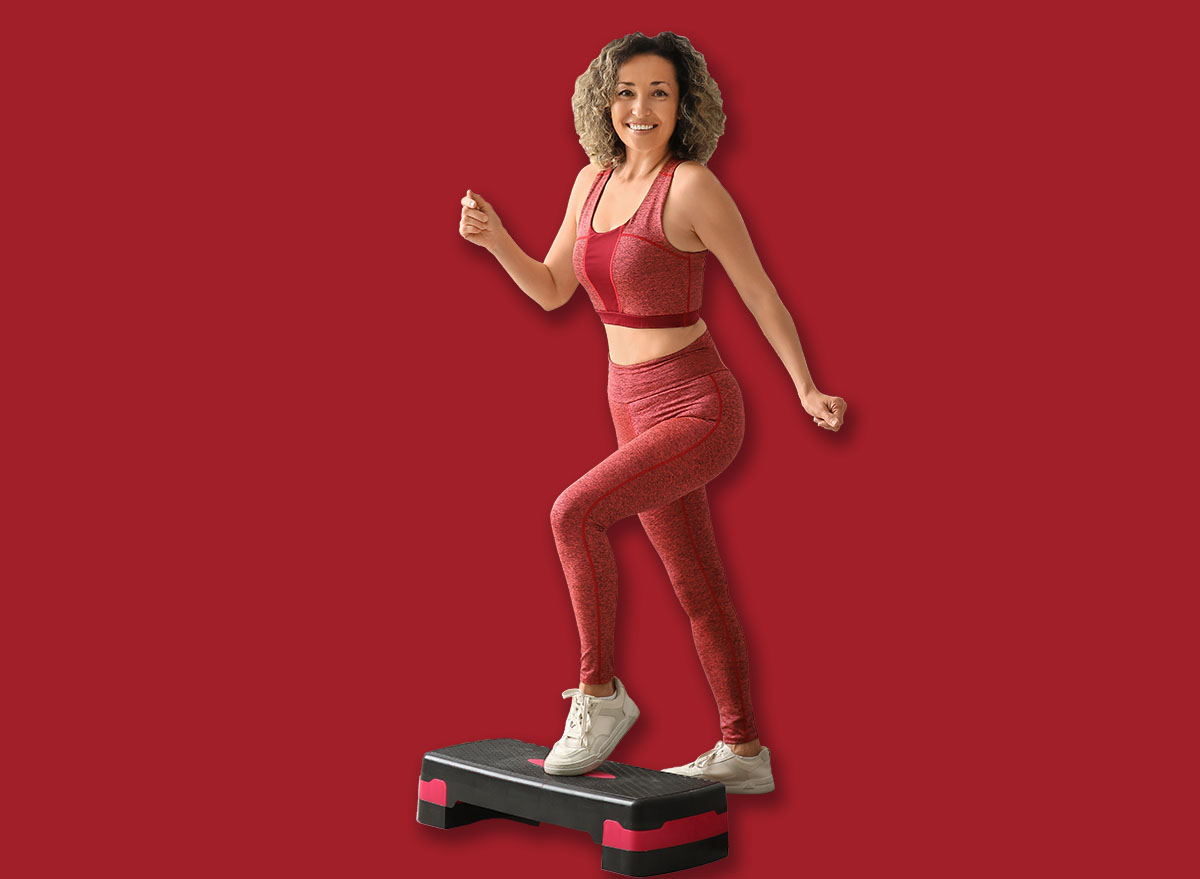 Happy mature sporty woman training with stepper at home