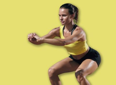 Fitness woman exercising, doing squat exercise workout at outdoor gym. Sport girl in sports wear squatting at street