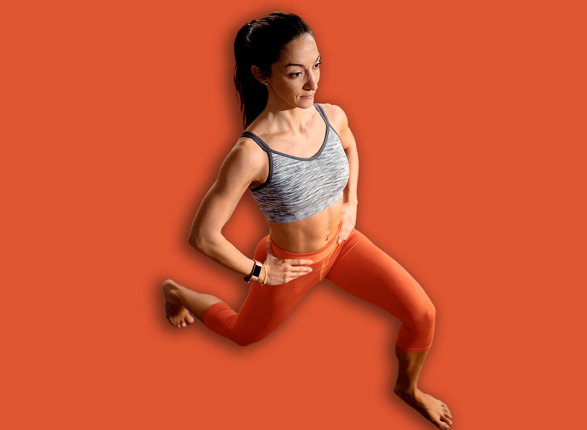 High angle view of athletic woman doing lunges while working out in the living room.