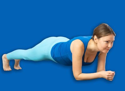 Concentrated sporty young woman doing bodyweight workout for core muscles in fitness studio, holding plank pose on forearms