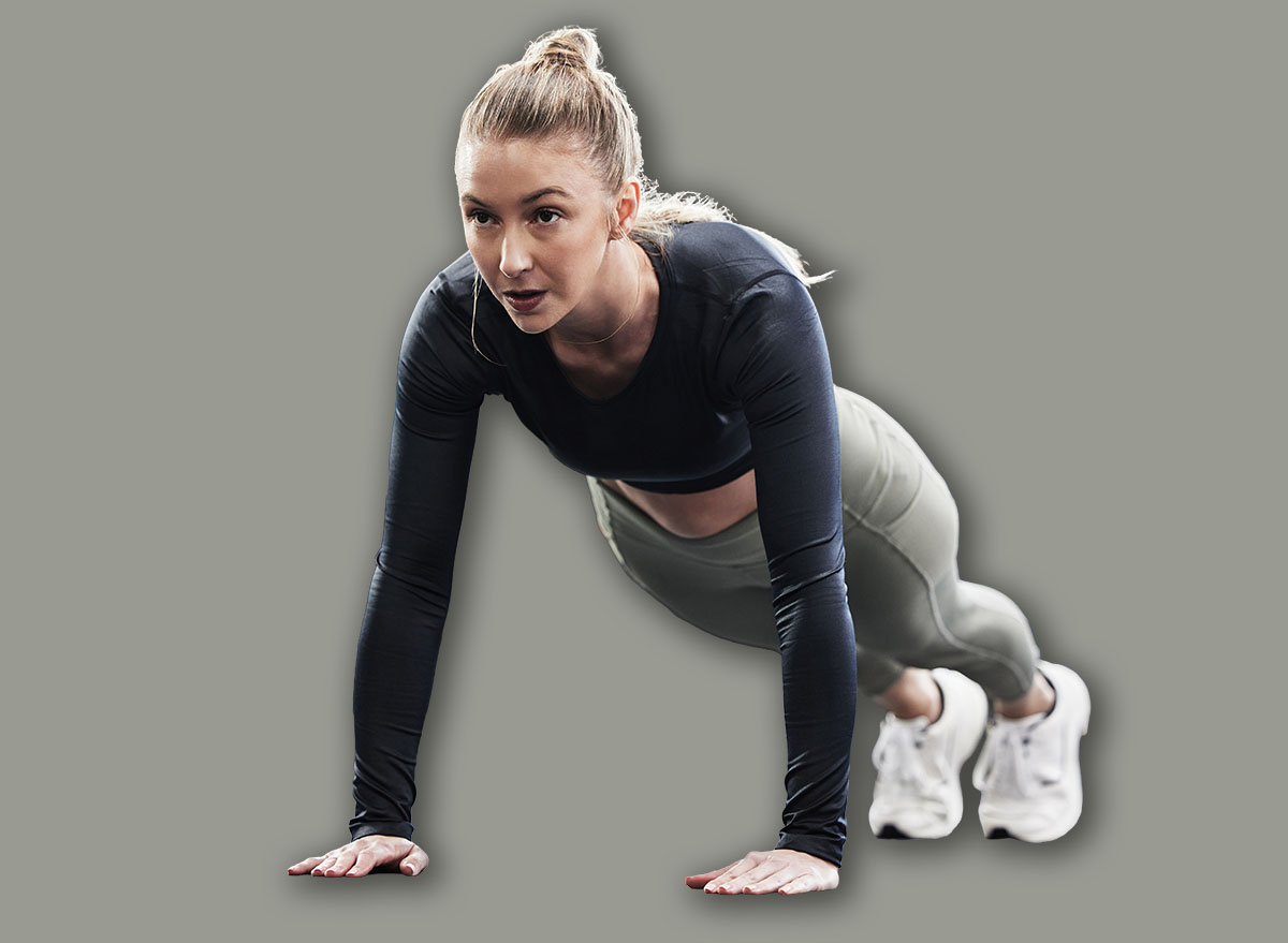 Fitness, push up and woman in gym for exercise, bodybuilder training and strong muscles. Healthy body, sports center and female person do pushup on floor for wellness, performance and cardio workout