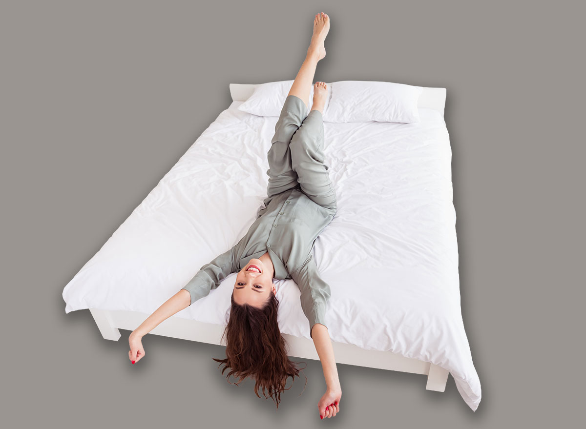 Top above high angle view portrait of attractive cheerful girl lying on bed stretching good mood at home house light white interior