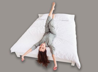 Top above high angle view portrait of attractive cheerful girl lying on bed stretching good mood at home house light white interior