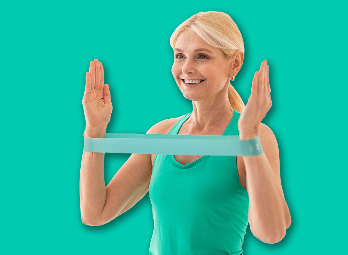 Active Lifestyle. Smiling Senior Lady Exercising With Resistance Band At Home, Portrait Of Sporty Mature Woman In Activewear Training With Fitness Equipment In Light Living Room Interior, Copy Space