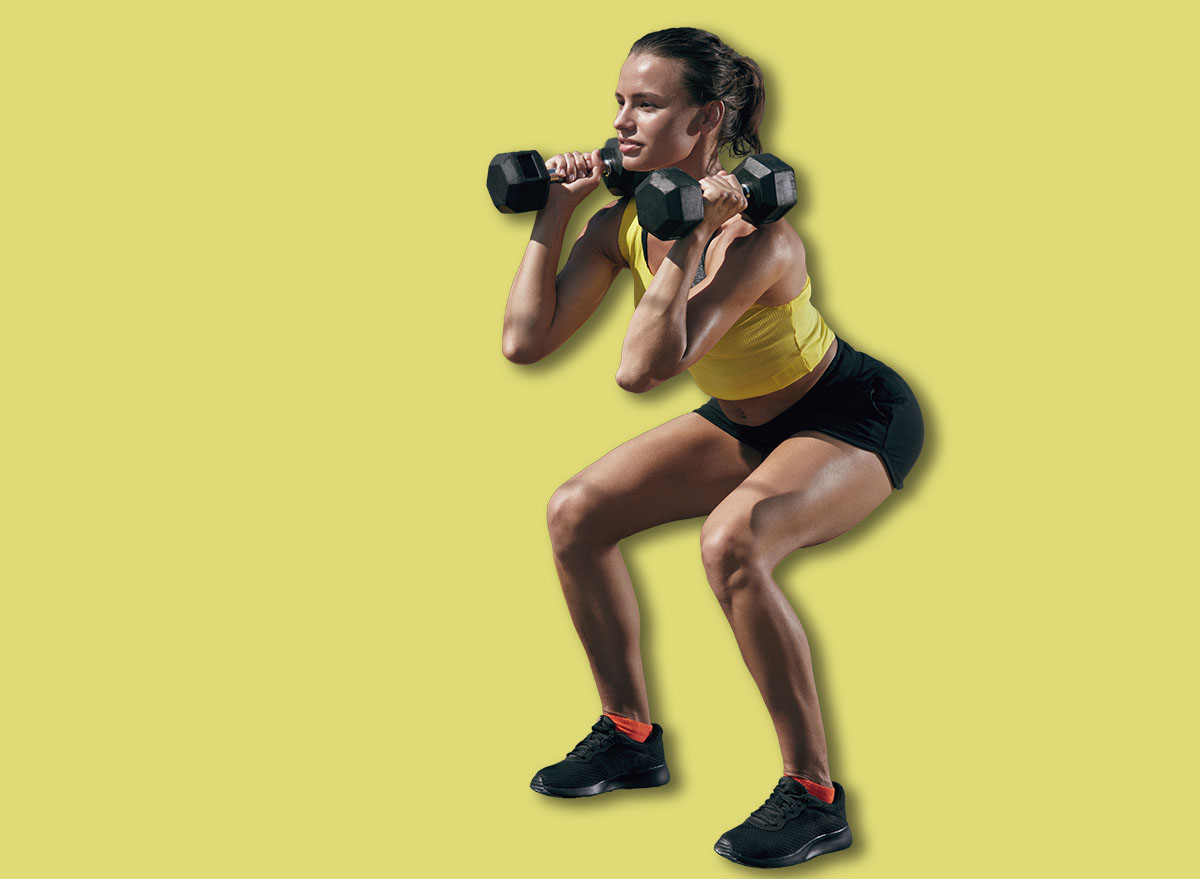 Fitness workout. Sport woman doing squat exercise with dumbbell at gym. Girl in sports clothes squatting, exercising outdoors on street