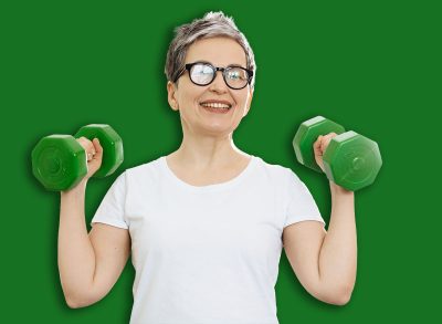 Senior woman lifting green dumbbells, smiling while doing a bicep curl. Promoting home workout, health and active aging