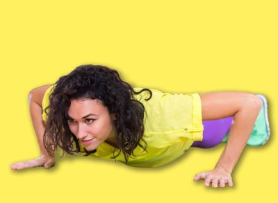 Two women doing push-ups on mats exercising in a gym