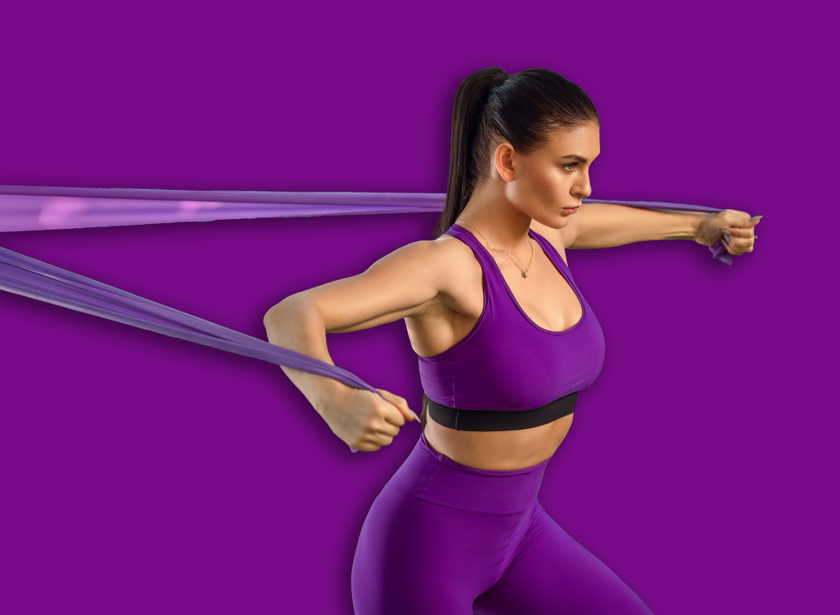 Young woman is training with rubber bands outdoors. Healthy active lifestyle concept. girl doing fitness in the park