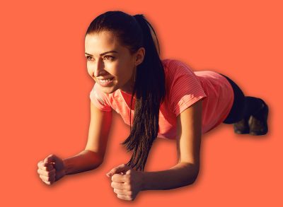 Girl does a plank exercise by the lake on nature