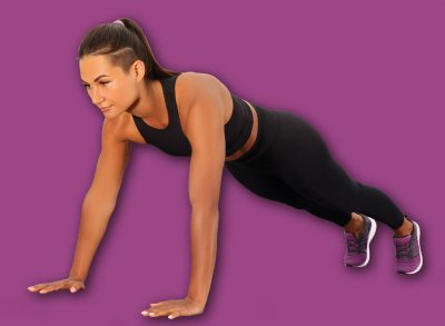 Young woman doing high plank exercise on wooden pier near river