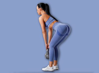 Fitness woman doing deadlift exercise for glutes on gray background. Athletic girl working out with kettlebell