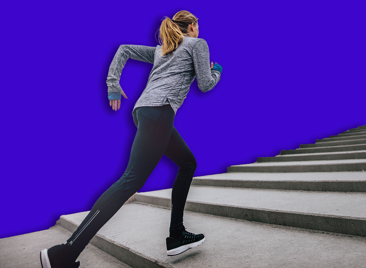 Outdoor shot of fit young woman running on steps. Runner exercising on stairs in morning.
