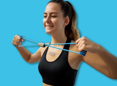 A female athlete in activewear sitting , pulling an elastic band with bent elbows to strengthen her upper back and shoulder blades. Focus on home fitness and back health.