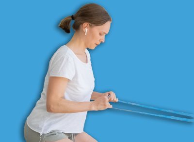 Tired focused young woman exercising with elastic resistant band on terrace, doing squat. Side view, copy space. Home fitness or lockdown workout concept