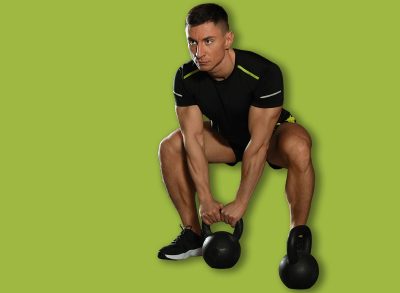 Strong man working out with kettlebell in modern gym