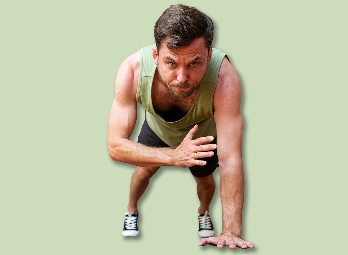 man doing plank shoulder tap exercise at home. Healthy and sporty lifestyle.
