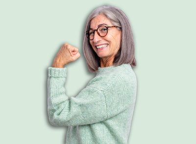 senior pretty woman feeling happy, satisfied and powerful, flexing fit and muscular biceps, looking strong after the gym