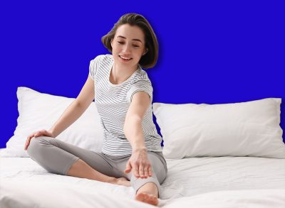 Young woman exercising on bed at home. Morning routine