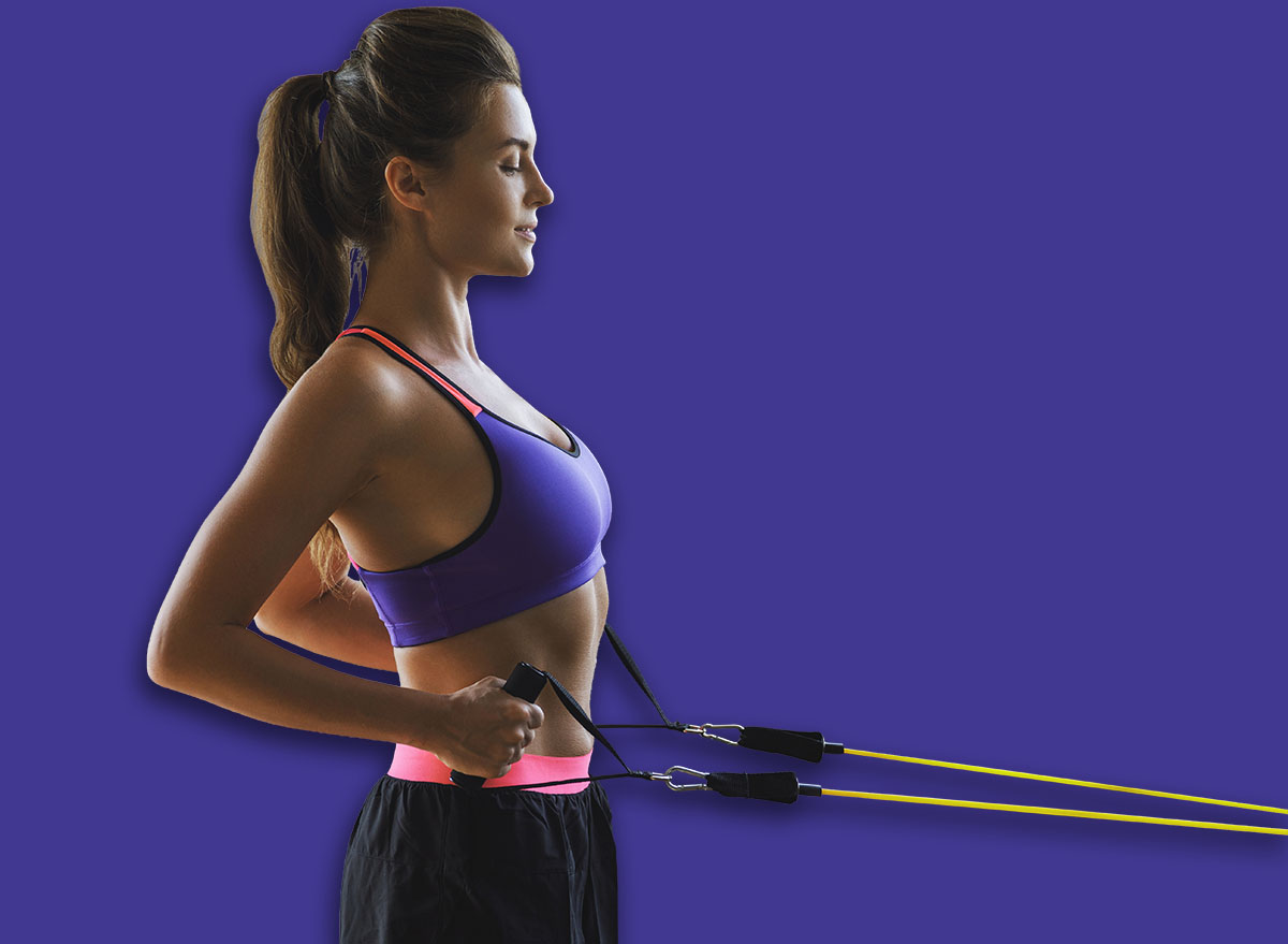 Woman during home workout with a rubber resistance bands