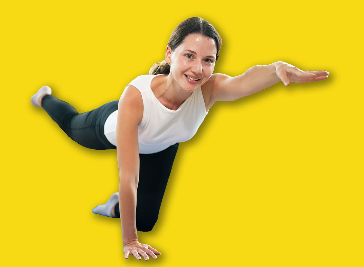 Female performing core stability balance exercise on yoga mat indoors, Practicing Bird Dog Exercise.
