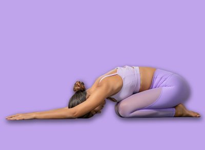 Side view of Asian woman wearing purple sportwear doing Yoga exercise,Yoga Child’s pose or Balasana. Calm of healthy young woman breathing and meditation with yoga at home. Exercise for wellness life