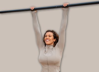 Woman training calisthenics, hanging on pull-up bar, fitness workout