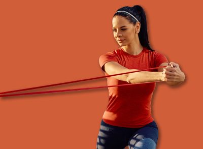 Young sportswoman using power band while exercising outdoors. Copy space.