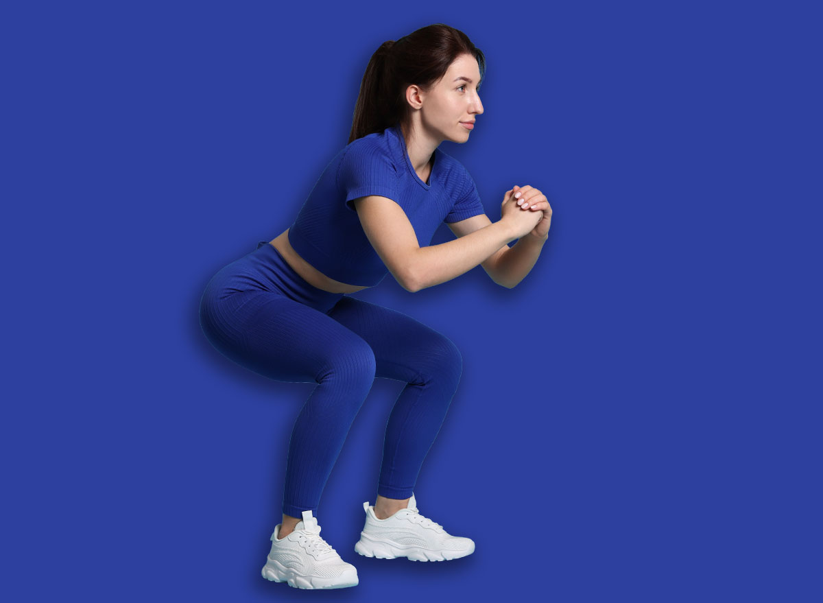 Woman in sportswear exercising on light blue background