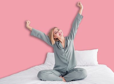 Full length body photo of young blonde girl in cozy grey victoria secret brand pajama wake up morning raised fists yawning indoors