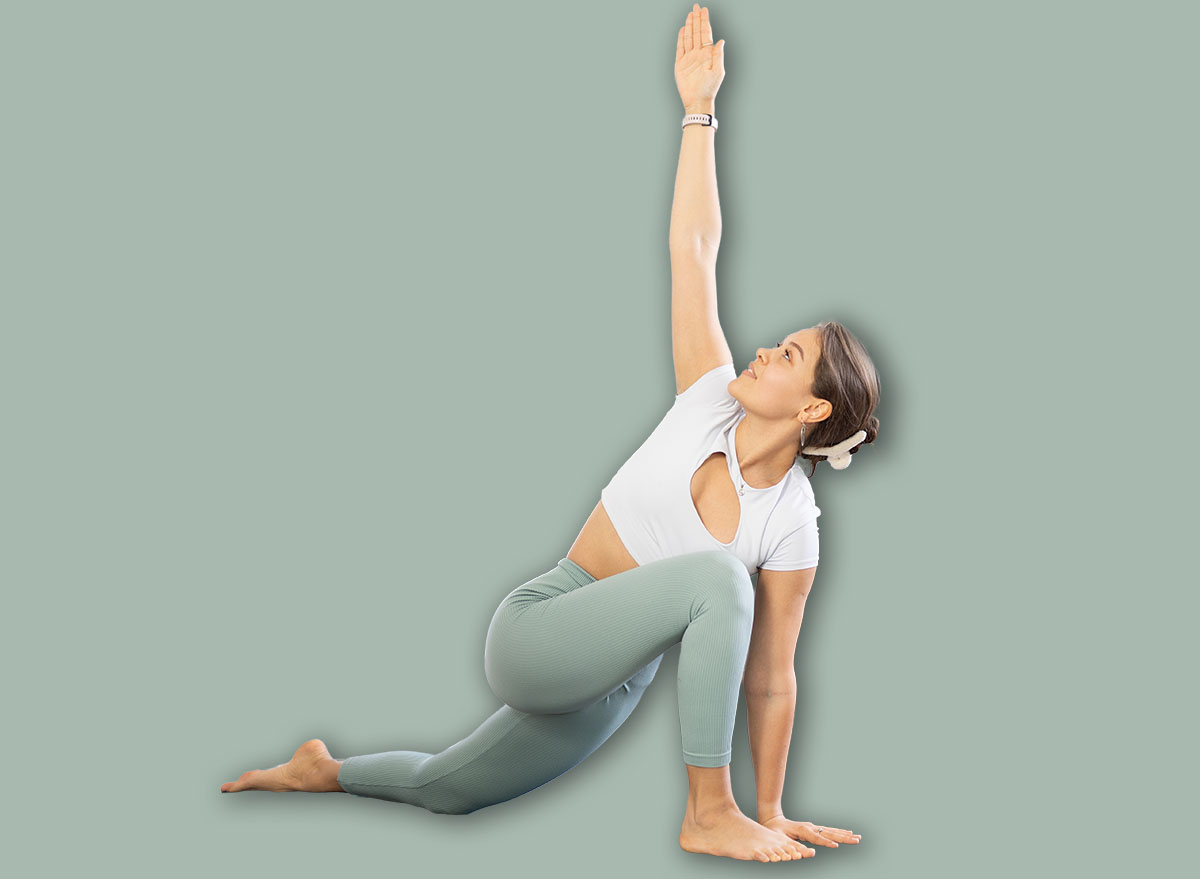 Positive young girl with group of female yoga enthusiasts performing Anjaneyasana with twist, Low Lunge with back knee grounded and torso twist, enhancing spinal mobility and core strength in studio