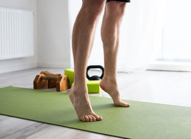 Sporty Young Man Practices Yoga And Does Standing Calf Raises For Strong Legs