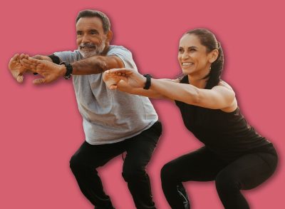 Happy senior caucasian couple in sportswear squats, enjoy training together on beach in morning, outdoor, full length. Health care, relationships, sports teamwork and active lifestyle
