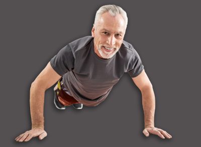 Sporty mood. Positive delighted retirement keeping smile on his face and doing push-ups while taking care of his health