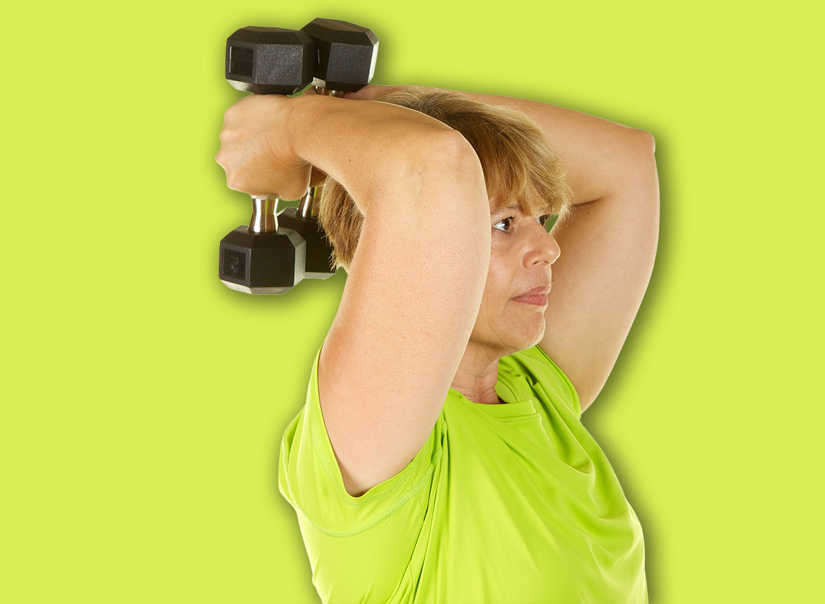 Mature woman lifting weights on a white background.