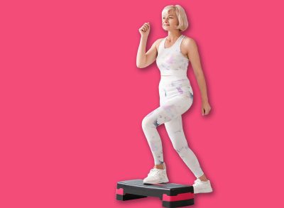 Sporty beautiful mature happy woman training with aerobic stepper at home