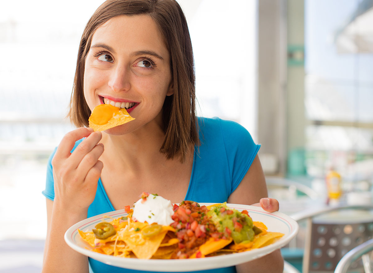 young woman in a restaurant having nachos
