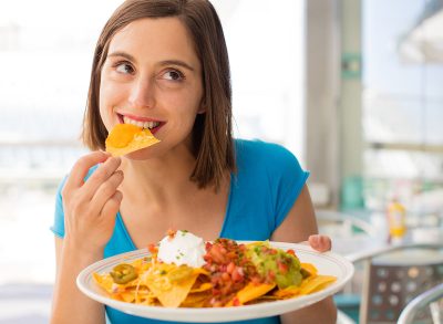 young woman in a restaurant having nachos