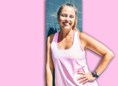Middle age sportswoman smiling happy leaning on the wall at the city