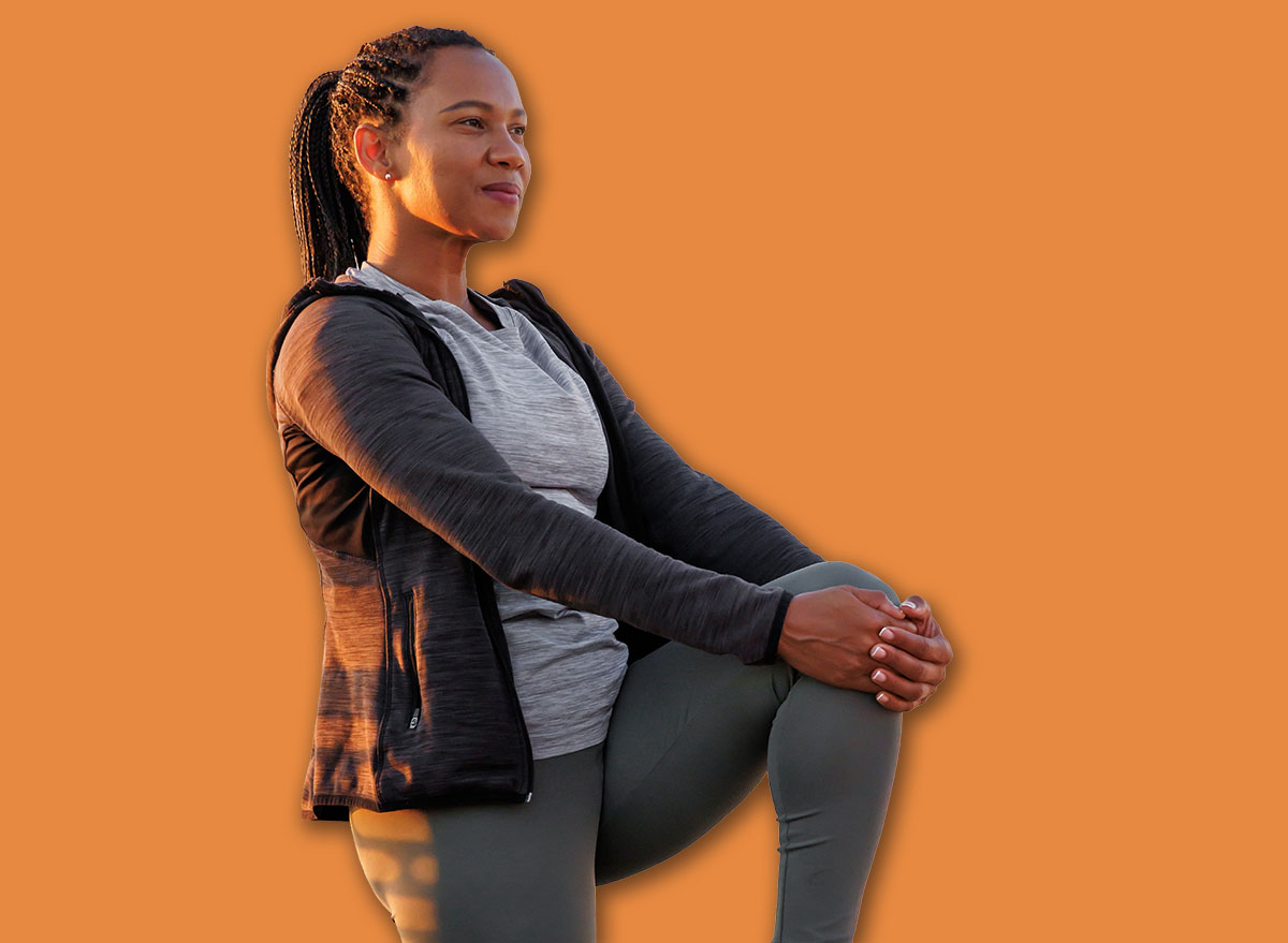 Active woman in sportswear warming up and stretching out before morning jogging or outdoor workout session