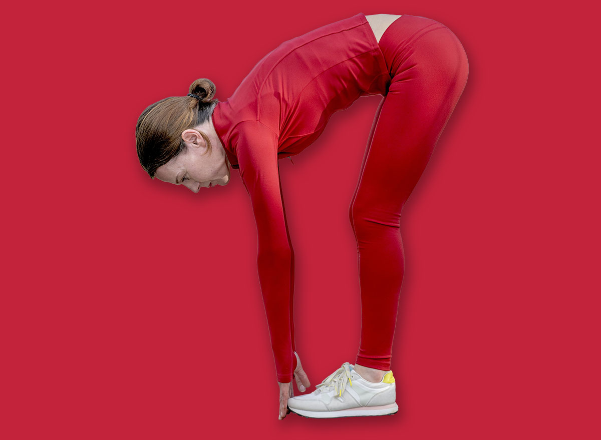 sporty woman touching her toes, warm up exercises outdoors.