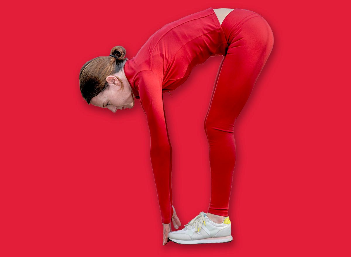 sporty woman touching her toes, warm up exercises outdoors.