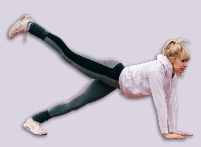 Beautiful Caucasian blonde woman doing plank leg raises on the racetrack before running. Full length, side view.