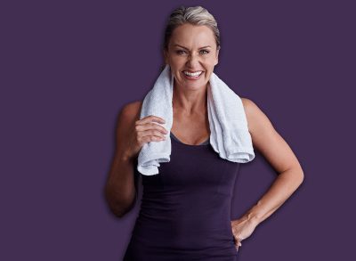 Workout, portrait and happy woman with towel in studio, exercise commitment and health training to lose weight. Space, cloth or mature person with fitness for wellness, body goals or gray background