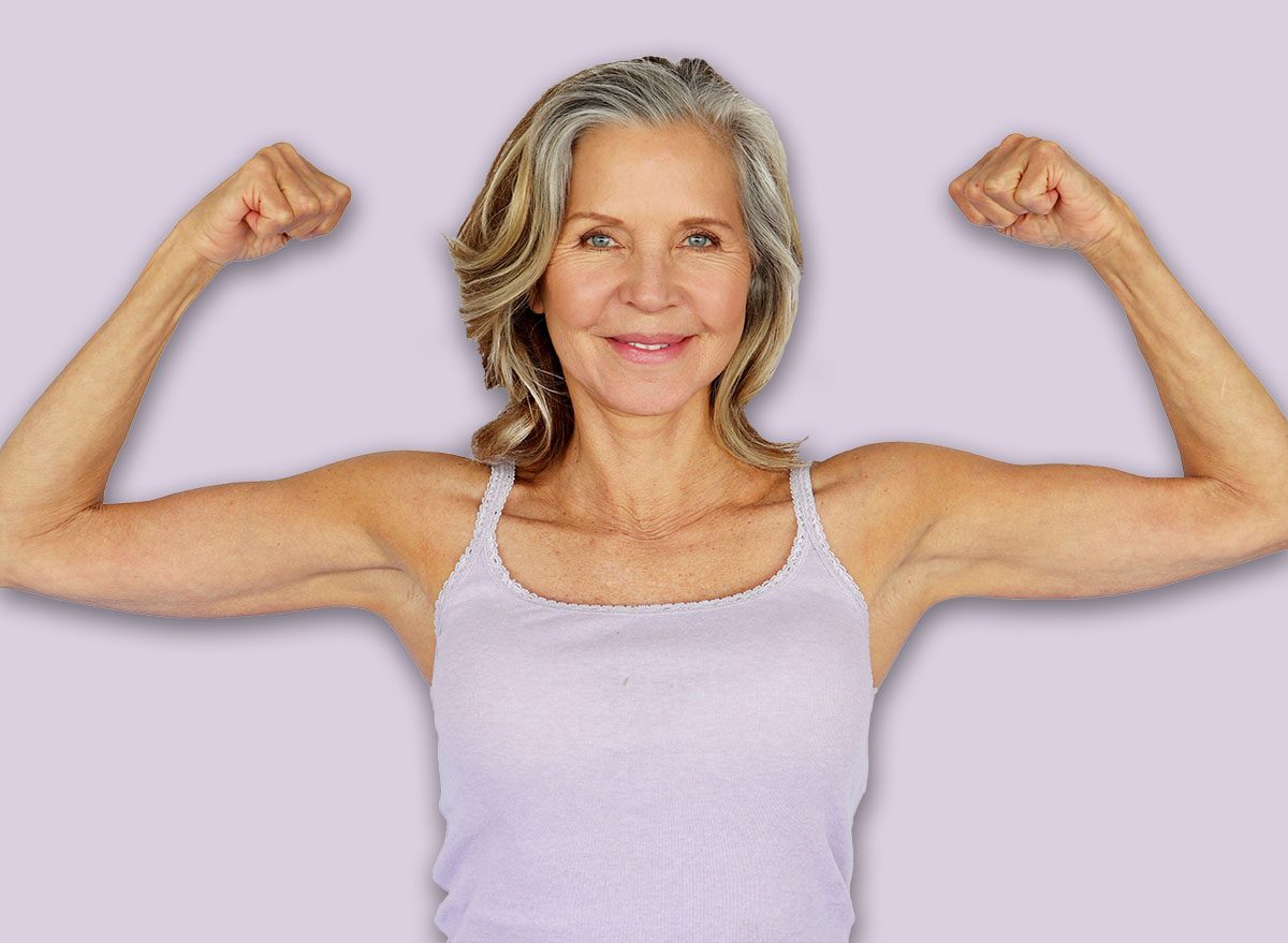 Beautiful Fit Mature woman flexing biceps in workout clothes