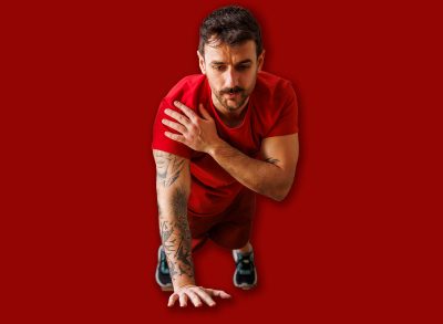 Active fit couple in sportswear doing plank shoulder taps exercise while working out together at home