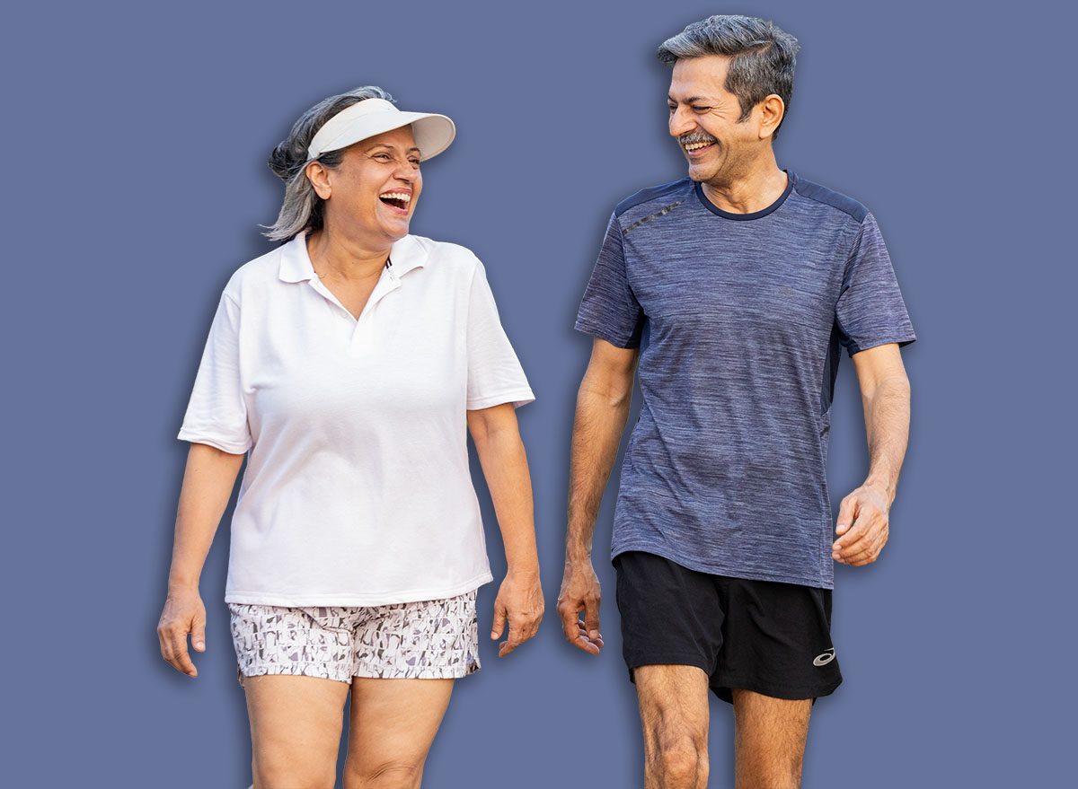 Mature Indian couple jogging together on walkway for fitness, happiness, and wellness.
