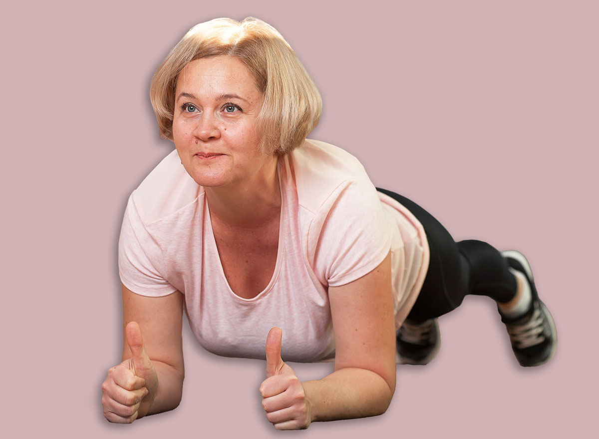 Charming Middle aged woman standing in plank position after a workout. The concept of health and longevity