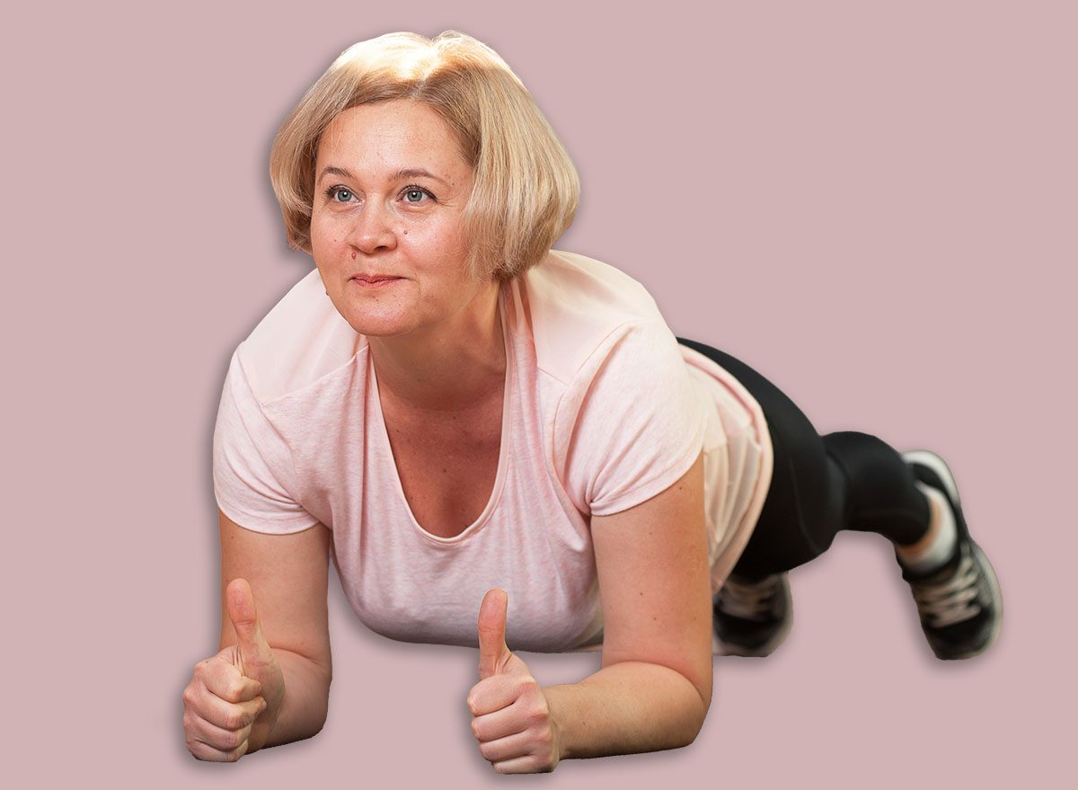 Charming Middle aged woman standing in plank position after a workout. The concept of health and longevity