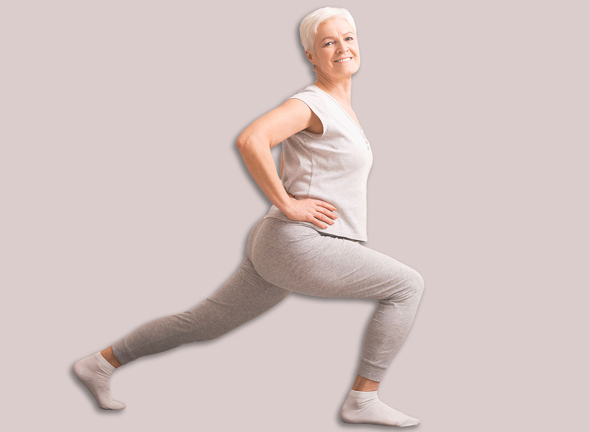 Legs stretching. Sporty senior lady doing lunges at home, empty space